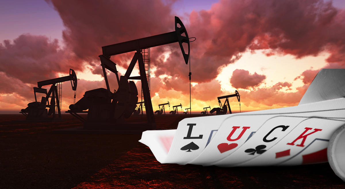 Poker cards with the letters L, U, C, K written on them in front of an oil field pump jacks at sunset