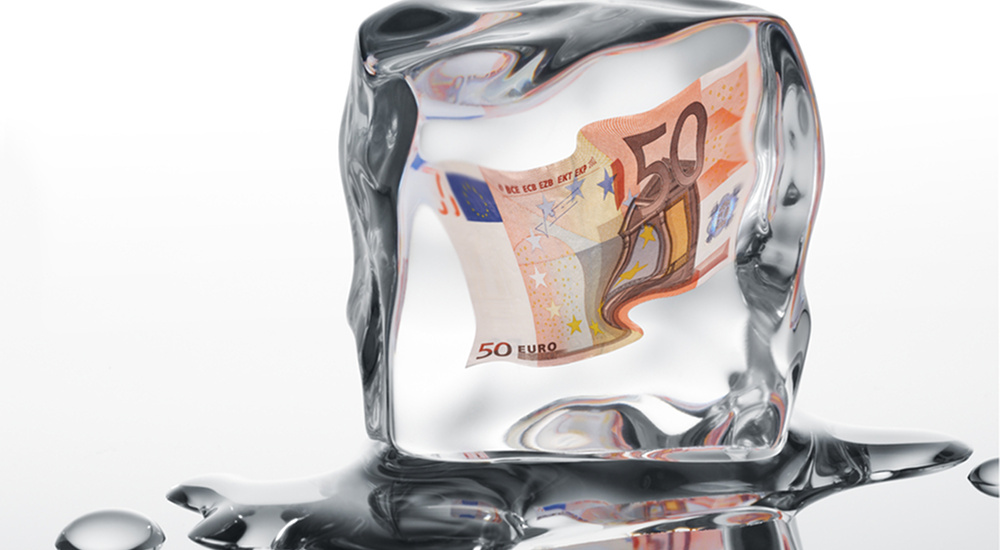 Euro banknote frozen in ice cube - financial crisis concept